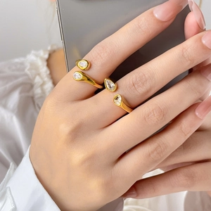 Detail of two 18K gold plated snake rings featuring pear-shaped cubic zirconia on finger