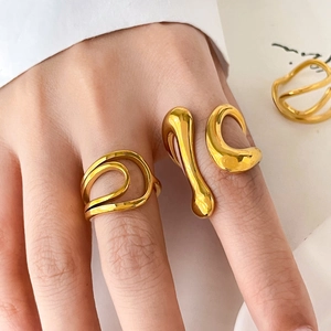 Macro detail of liquid style 18K gold plated minimalist curved rings on model hand