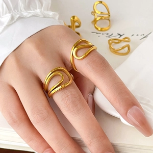 Close-up of minimalist 18K gold plated curved wave rings worn by a model in a lifestyle setting