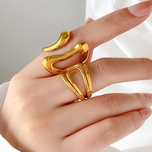 Macro detail of curved fluid 18K gold plated ring with irregular organic lines