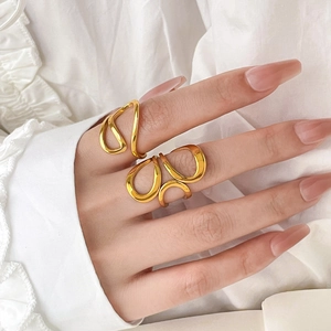 Minimalist 18K gold plated titanium rings featuring curved fluid lines in a stacked set