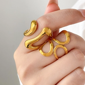 Close-up of sculptural curved 18K gold plated ring with liquid metal aesthetic style