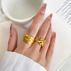 Anelli in acciaio dorato 18K con rilievo facciale astratto e design a torsione su mano