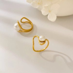 Detail of gold teardrop rings with white pearls and curved minimalist double layers