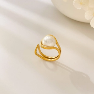 Detailed view of a double-layered gold ring with a teardrop pearl and purple crystal accents