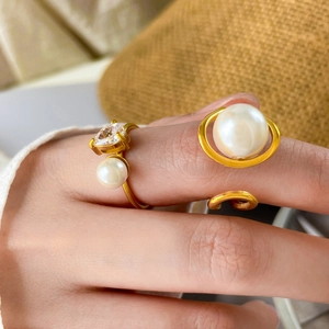 Detail of gold-plated teardrop pearl and heart zircon ring set on a model hand