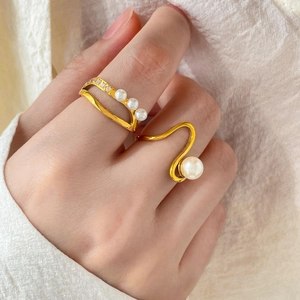 Close-up of double-layer gold teardrop rings with pearls and sparkling micro-pave diamonds