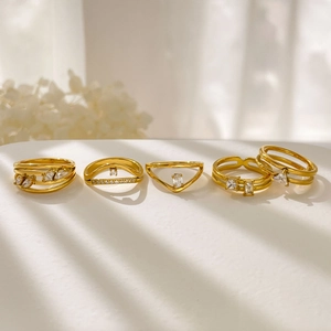 Ensemble de cinq bagues en acier titane plaqué or 18K avec cristaux de zircon