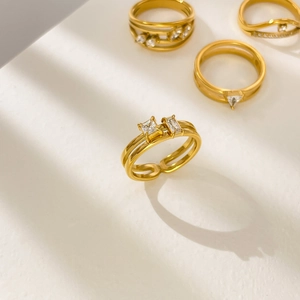 Détail d'une bague double couche plaquée or 18K avec zircon carré sous une lumière douce