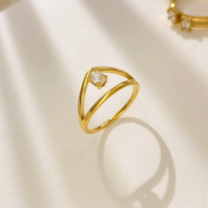 Vue macro d'une bague en V plaquée or 18K avec zircon ovale sur fond blanc pur