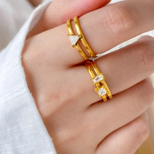 Gros plan de bagues doubles en titane plaqué or 18 carats avec zircons géométriques
