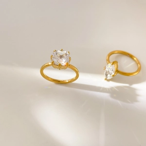 Gros plan de bagues plaquées or 18 carats avec zircons cubiques tailles émeraude et marquise