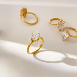Détail de quatre bagues plaquées or 18 carats avec diverses tailles de zircon cubique