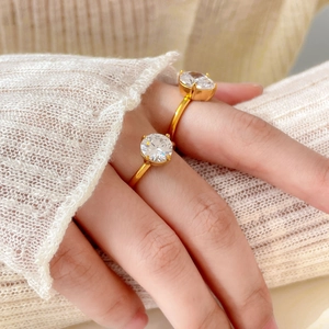 Détail d'une bague plaquée or 18 carats avec zircone ronde scintillante sertie à quatre griffes
