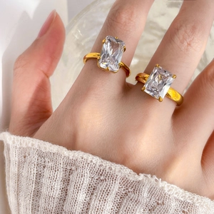 Détail de deux bagues plaquées or 18 carats avec de grands zircons taille émeraude