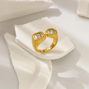 Macro view of gold-plated thick ring with square and round zircon on stone background