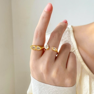 Close-up of gold plated teardrop and marquise zircon rings worn on a model's fingers