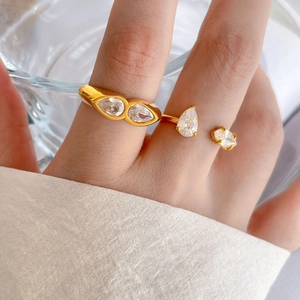Detail of two 18K gold plated titanium rings featuring sparkling pear-cut zircon stones