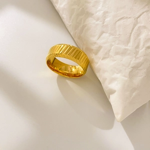 Macro shot of 18K gold plated titanium ring featuring diagonal textured groove details