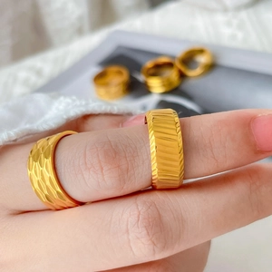 Polished 18K gold-plated titanium rings with diagonal textured and grooved design