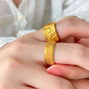 Detail view of 18K gold-plated titanium ring with textured diamond and twill patterns