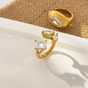 Detail of 18K gold plated ring featuring rectangular and oval cubic zirconia stones