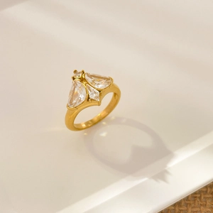 Macro detail of 18K gold-plated butterfly zircon ring on white ceramic plate