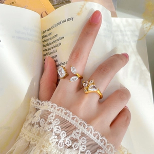 Close-up of elegant 18K gold plated rings with zircon stones on a vintage book