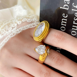 Close-up of 18K gold plated rings featuring heart and oval zircon stones on a model