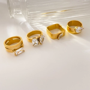 Set of four 18K gold plated teardrop and square zircon rings on a white surface