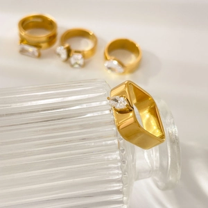 Detailed view of 18K gold plated ring with marquise-cut zircon against glass surface