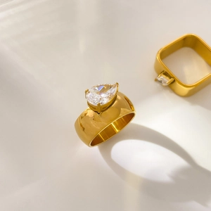 Macro detail of 18K gold teardrop and square rings set with sparkling zircon stones
