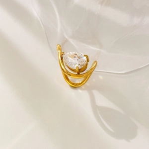 Detailed view of an 18K gold ring featuring a pear-shaped zircon and a spiral band