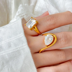 Close-up of 18K gold plated emerald and pear cut zircon rings on model finger