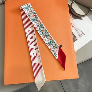 Detail of floral and striped long scarf wrapped on a luxury orange gift box for styling