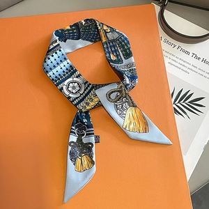 Elegant silk twilly scarf with floral pattern displayed on a signature orange gift box