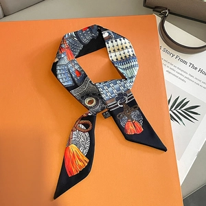 Detail of luxury silk twilly scarf with vintage armor print on an orange gift box