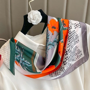 Floral print silk scarf with geometric patterns draped on a hanger with a white shirt