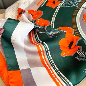 Close-up of premium floral silk scarf showing smooth texture and green poppy print