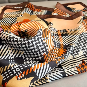 Close-up of houndstooth silk scarf showing fine fabric texture and elegant edge stitching