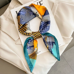 Elegant houndstooth silk scarf with bright color-block geometric patterns on white blazer