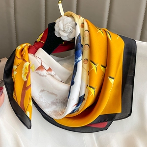 Elegant yellow floral silk scarf with ginkgo leaf patterns on a luxury hanger