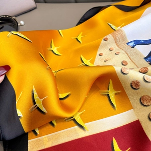 Detailed close-up showing soft silk texture and vibrant bird prints on a silk neck scarf