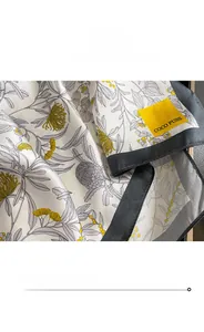 Nahaufnahme der Seidenschal-Kante mit Blumenmuster und gewebtem Etikett für Damen