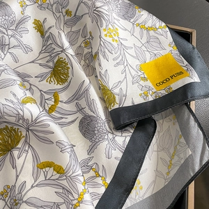 Seidenquadrat mit Blumenmuster in Elfenbein und Gelb auf einer Luxusgeschenkbox