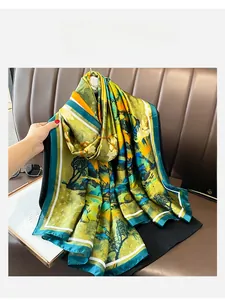 Detail of silk scarf showing landscape print with green and yellow satin texture