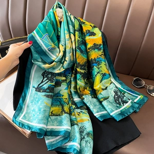 Elegant lake green silk shawl with mountain landscape print on dark sofa background