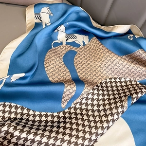 Detailed view of horse print silk scarf featuring houndstooth pattern and satin texture