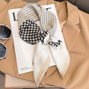 Chic houndstooth silk scarf on magazine with sunglasses and camel blazer for style