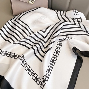 Foulard in seta bianca con strisce geometriche nere e un design elegante di lettere